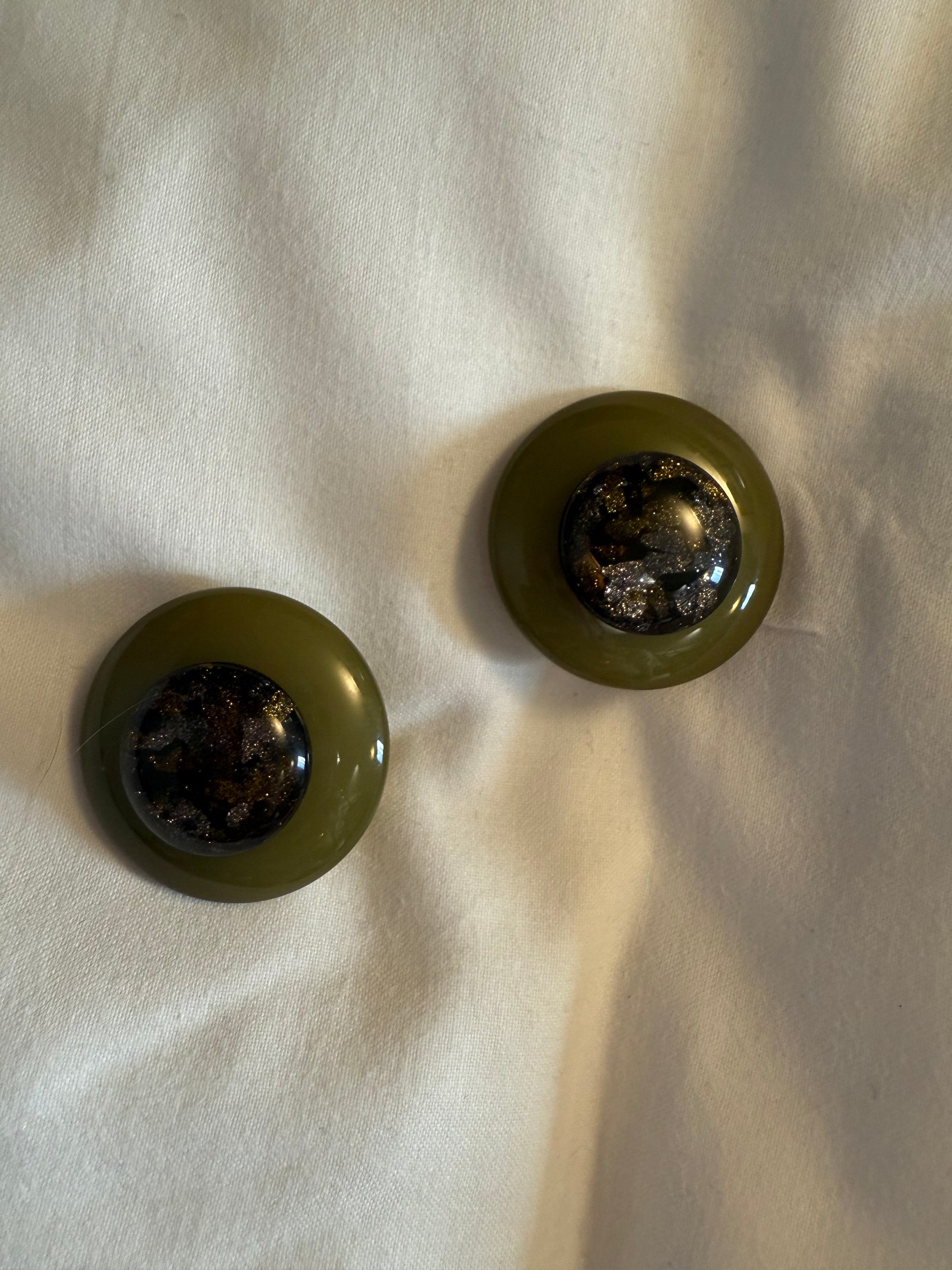 Boucles d’oreilles FRANCINE BRAMLI : cabochon vert kakis et élément pailletée. ( marie claire)